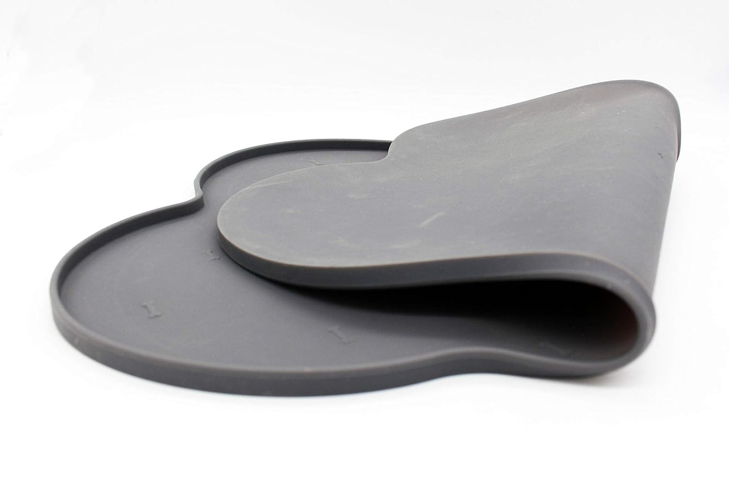 Silicone anti-spill pet feeding mat in waterproof, non-slip bone shape by Loom and Latch, designed to catch spills during feeding.