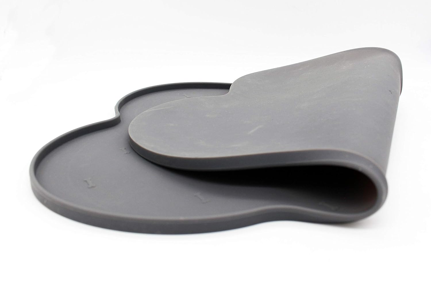Silicone anti-spill pet feeding mat in waterproof, non-slip bone shape by Loom and Latch, designed to catch spills during feeding.