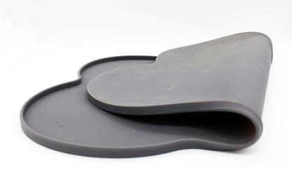 Silicone anti-spill pet feeding mat in waterproof, non-slip bone shape by Loom and Latch, designed to catch spills during feeding.